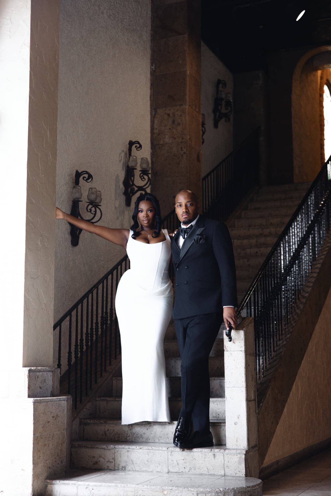 Bride and groom on a sweeping stone staircase