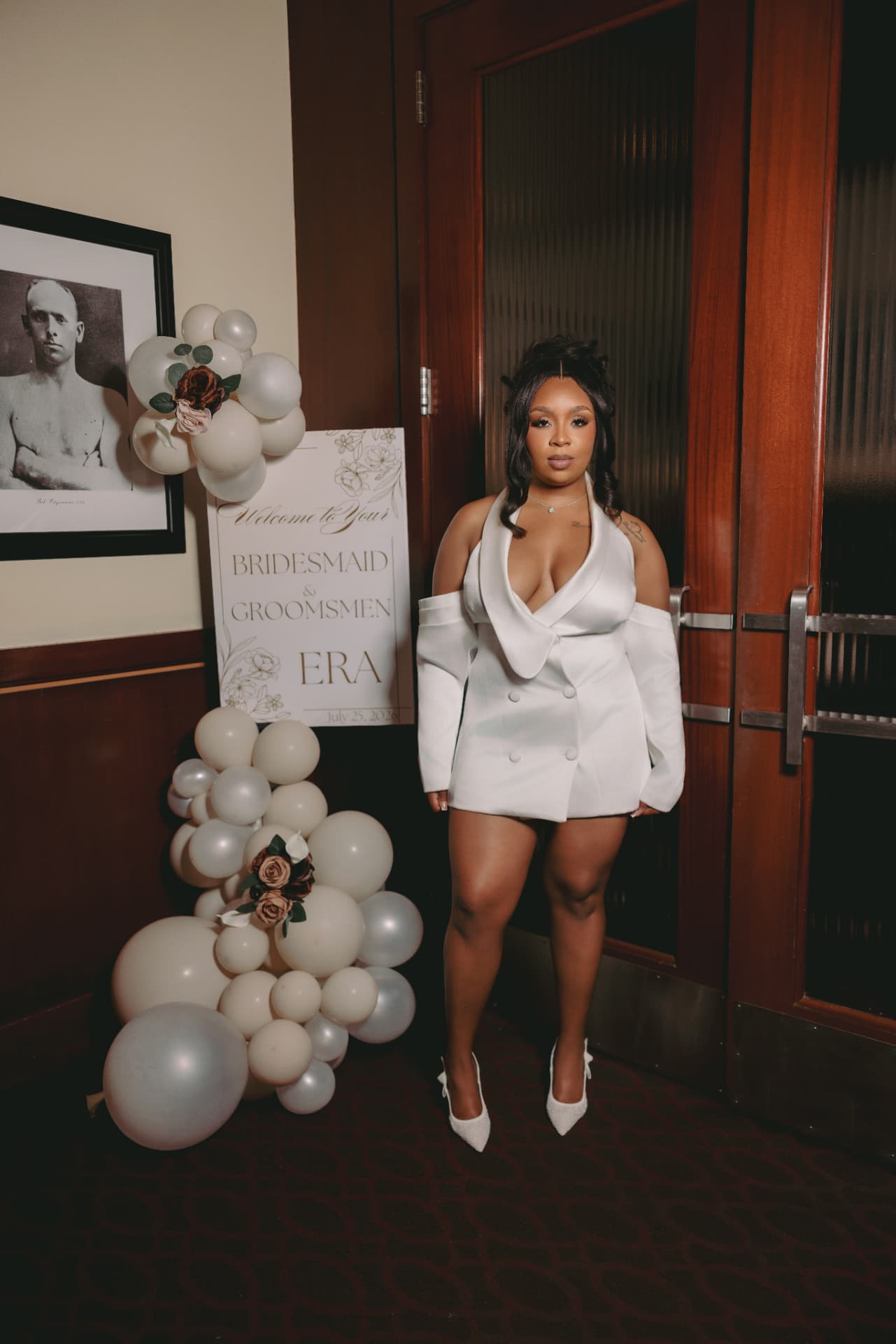 Bride in a white suit dress beside a balloon arrangement